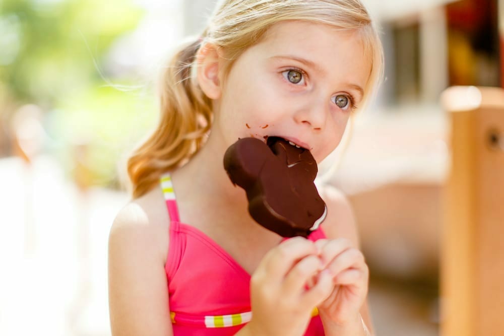 Little girl eating mickey mouse shaped ice cream