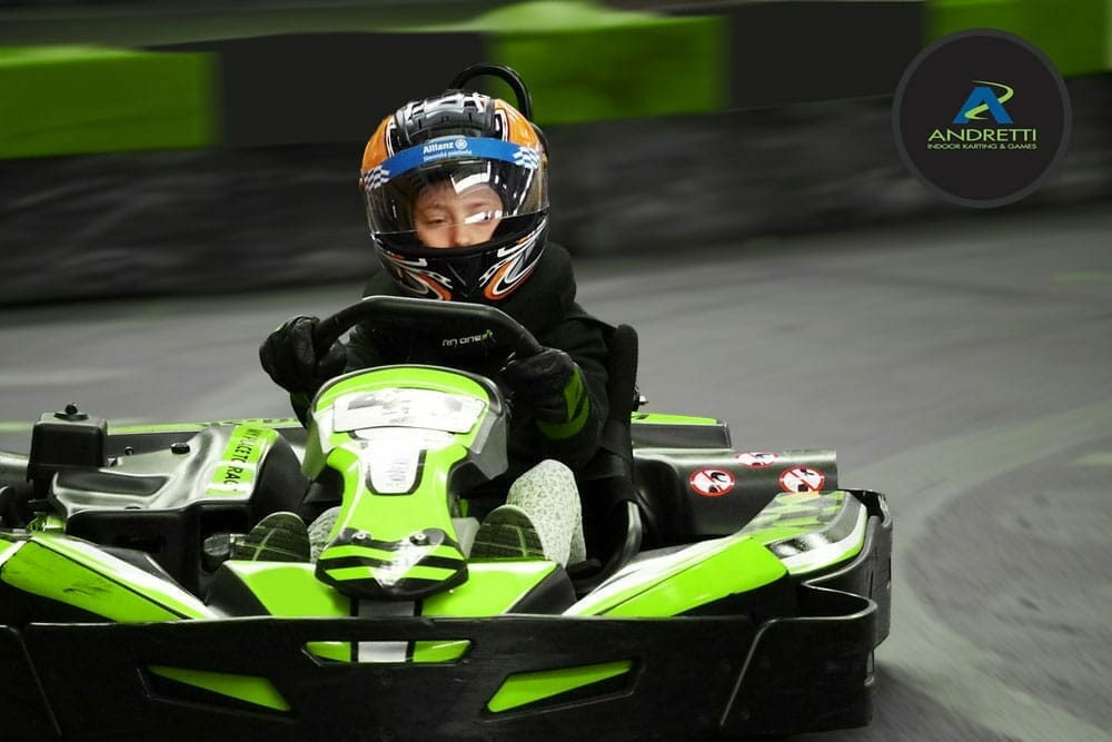 Kid racing in a green go-kart
